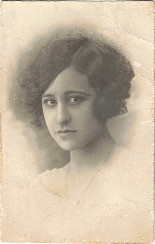 Retrato en blanco y negro de una joven de hace cien años en una postal antigua.