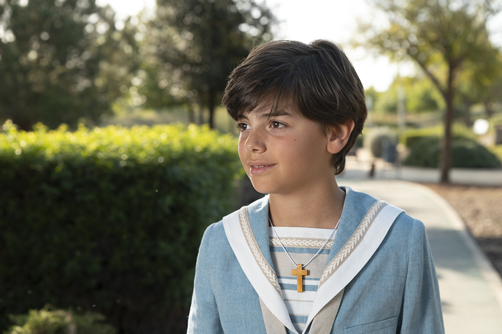 Primer plano de Miguel vestido de marinero para su primera comunión